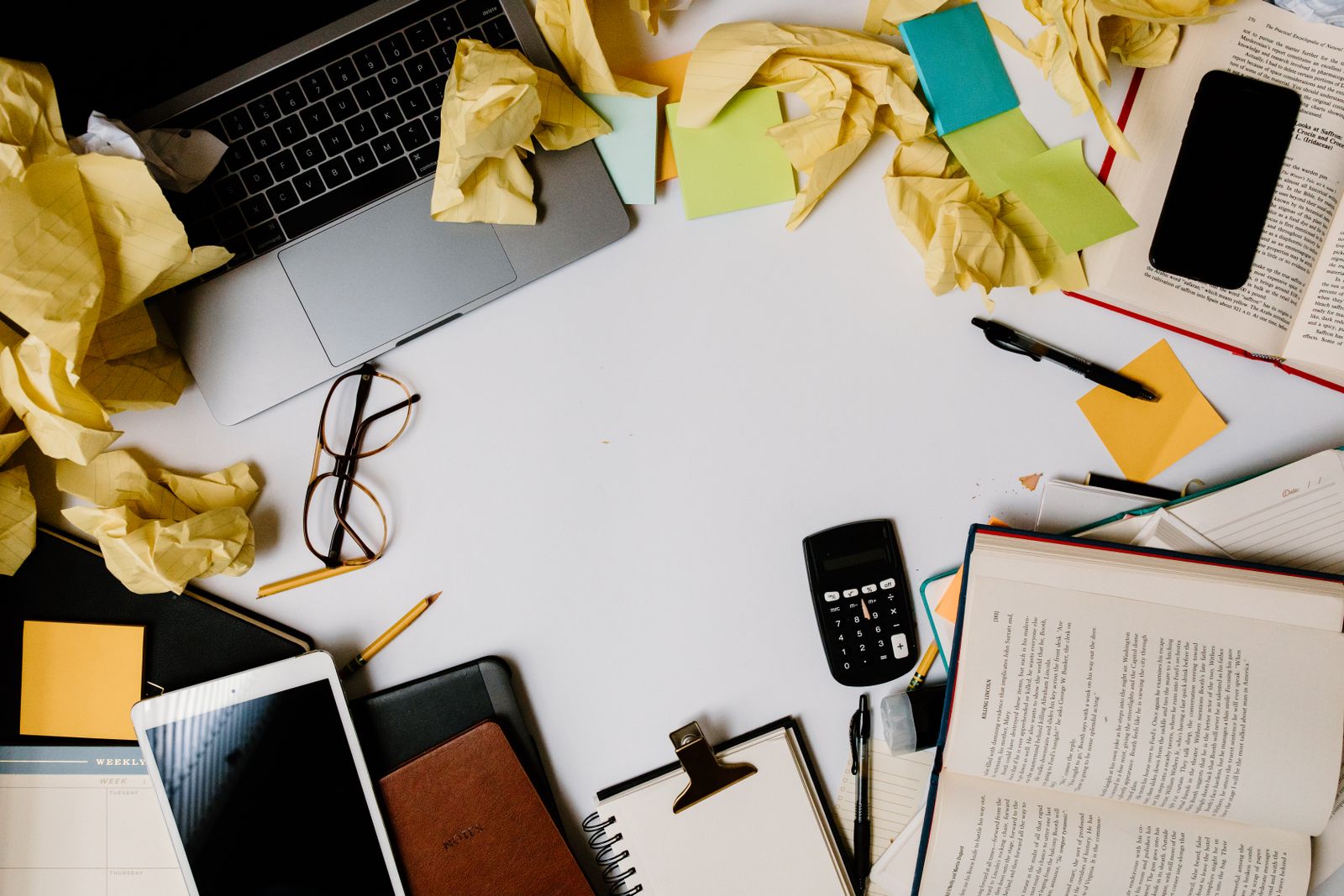 Cluttered desk with crumpled papers and a laptop representing a messy blog feed